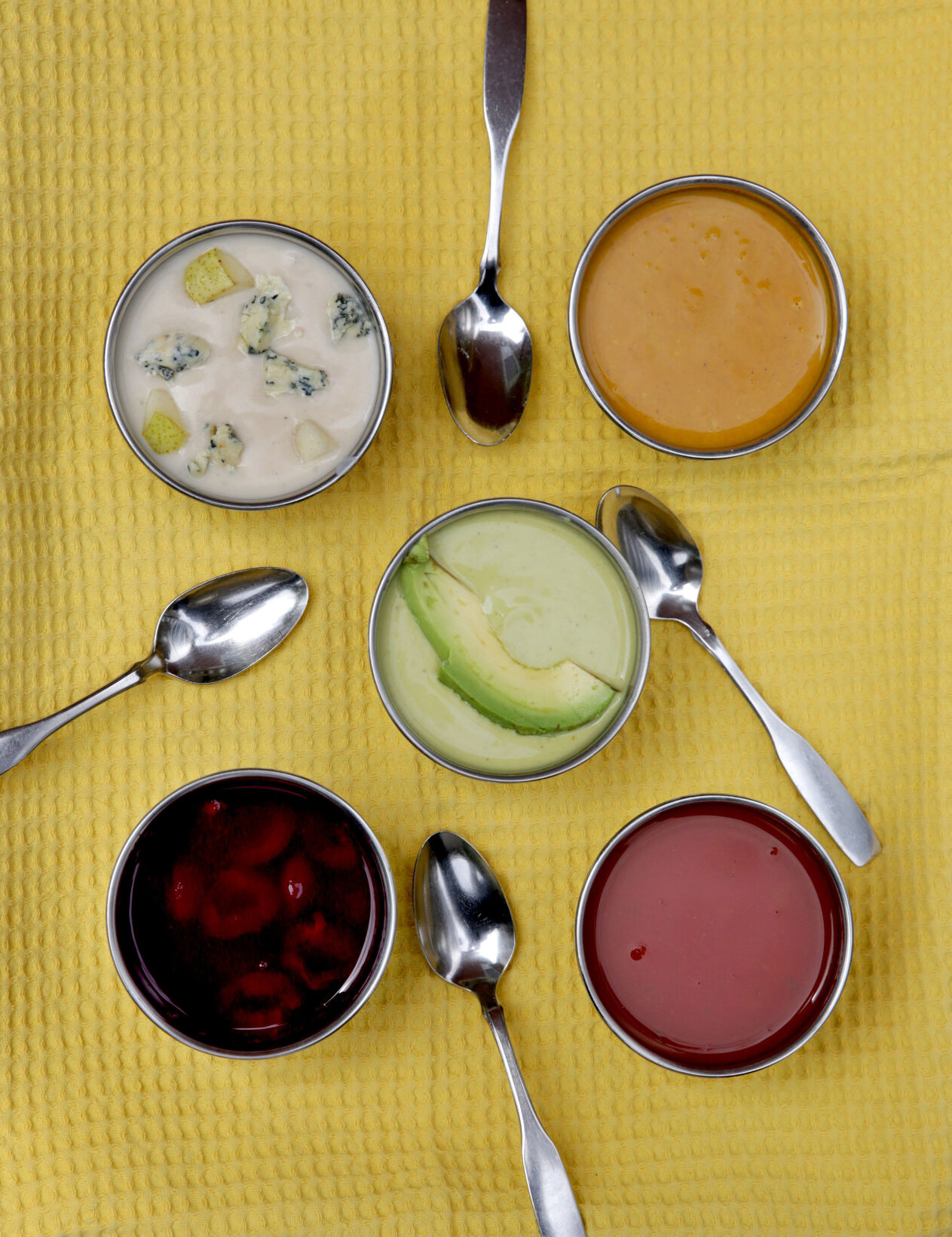 Summer soups, clockwise from top left: Chilled Stilton and Pear Soup, Cold Carrot-Coconut Soup, Lightly Spiced Tomato Soup, Cherry Soup, and center, Curried Avocado Soup, photographed Wednesday, July 15, 2020.